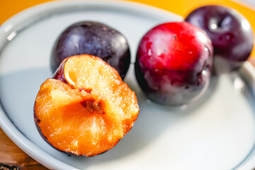 Fresh black plums on cutting board