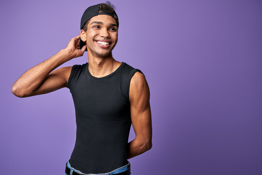 Happy young transgender man smile portrait. Cheerful latino male in black t-shirt. Purple background