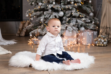 baby boy near Christmas tree at festive decorated home