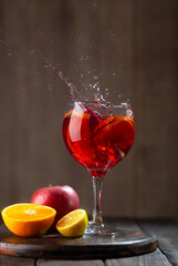 Sangria in glass with splashes and ingredients - orange, lemon and apple