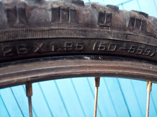 Part of a mountain bike tire with the markings of the tire dimensions in inches and in ETRTO standard 