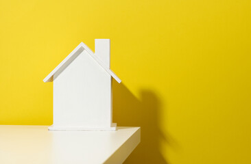 Fototapeta na wymiar white wooden house on a yellow background. Real estate rental, purchase and sale concept. Realtor services