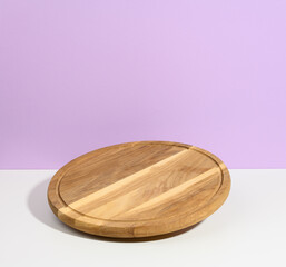 round wooden kitchen pizza board on a purple background, utensils levitate