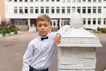 A beautiful eight-year-old boy in a school uniform