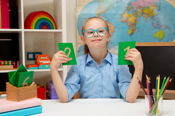 A girl with Down syndrome is sitting at a desk