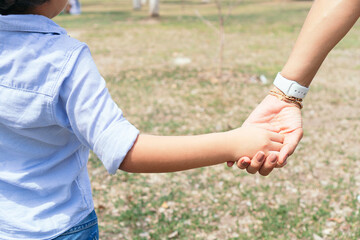 Woman's and kid's hands. Mother leads her child, nature outdoor. Family concept.