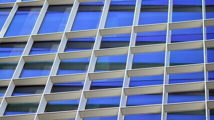 Modern office building with glass facade on a clear sky background. Transparent glass wall of office building.