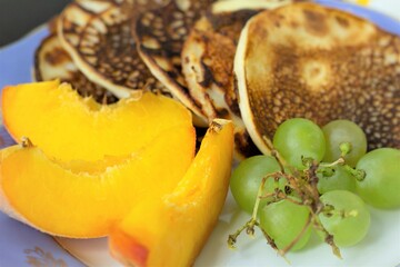 Closeup fruit on a plate with pancakes tasty food eat grapes peach yummy nobody vegetarian organic