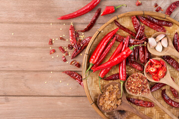 Chili with various seasonings on wooden floor top view with copy space