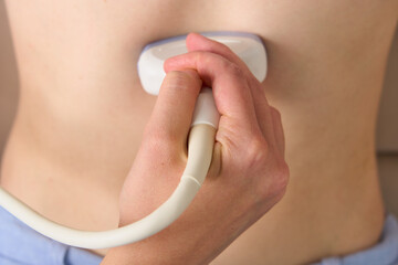 Closeup of ultrasound scanning abdominal cavity with convex probe sensor. Organ diagnostics at home. Soft tissues and intestines examination. Left lobe, liver, stomach arteries and veins scan