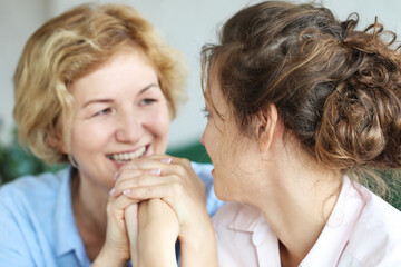 lifestyle, family and people concept: Happy young woman and her mother at home