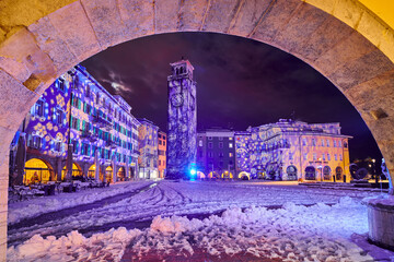 Christmas lights adorning the city center and Riva del Garda with snowy streets,View of the...
