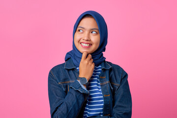 Portrait of smiling young Asian woman with hand on chin and looking to side