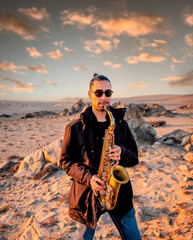 latin musician playing the saxophone in the desert in Atacama, Chile