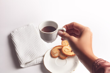 woman hand catching cup of breakfast with hot chocolate and palmeritas with white background