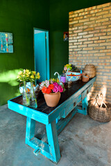 potted flowers on turquoise table and exposed brick wall, ornamental flowers