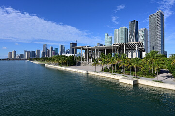 Fototapeta na wymiar City of Miami, Florida skyline reflected in Biscayne Bay under sunny summer cloudscape.