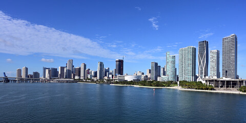 City of Miami, Florida skyline reflected in Biscayne Bay under sunny summer cloudscape.