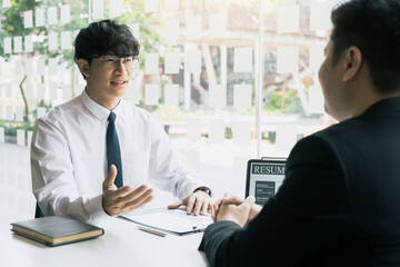 The interview room while the staff is preparing the resume document and presenting to the manager who is talking and analyzing about the work experience.