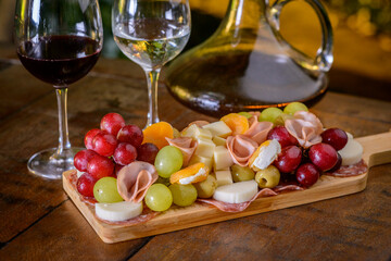 Cold platter and wine glasses on a wooden table.