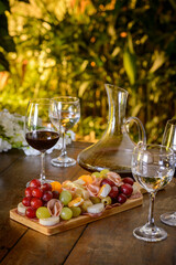 Cold platter and wine glasses on a wooden table.