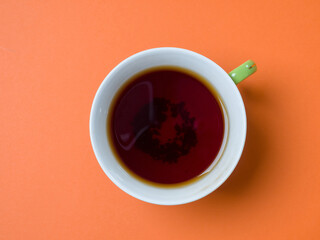 Mug of tea on an orange background. View from above. Studio photography
