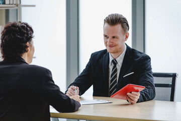 Executive caucasian manager laugh and smile as enjoy business talking together with happy colleauge woman during relax for discussion and consult about joyful teamwork at corporate office