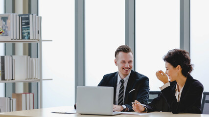 Executive caucasian manager laugh and smile as enjoy business talking together with happy colleauge...