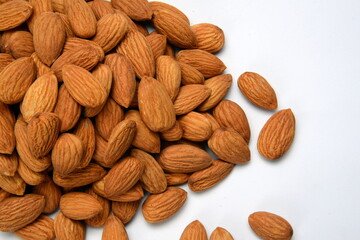Fresh almonds in the wooden bowl, Organic almonds, almonds border white background, Almond nuts on a dark wooden background. Healthy snacks. Top view. Free space for text.
