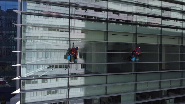 Window cleaners work on a glass building of Polanco neighborhood during a sunny morning in Mexico City, Mexico.
