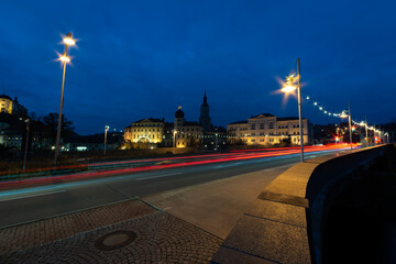 Fototapeta na wymiar colorful light stripes of cars on the street at night in front of a church in the city of plauen
