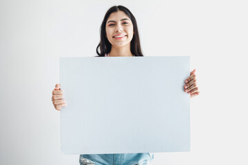 Naklejka premium Young latin woman holding a blank empty card isolated on white background in Latin America