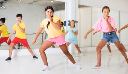 Children exercising modern dance moves together during their group classes.
