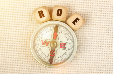 On the table is a compass and cubes with the inscription -ROE