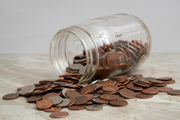 Jar of coins spilling on a table