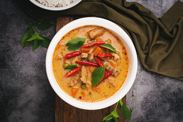 Panang Curry with Pork served with rice on a dark background.