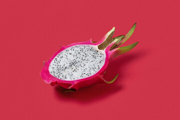 Dragon fruit cut in half in a plain red background