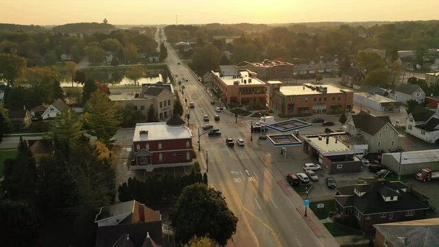 Sunny morning in a small quiet american town. Main street with shops, small business.  Establishing shot, aerial overhead view. 