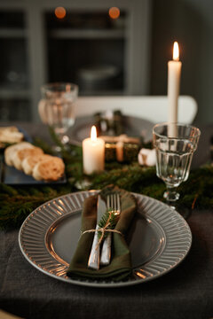 Vertical background image of black table setting decorated for Christmas with candles lit, copy space