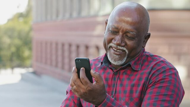 Overjoyed Senior Black Male Grandfather Waving Hand Making Video Call Looking At Smartphone Camera Talking On Modern Cellphone, Happy Mature African American Man Speak Have Pleasant Communication