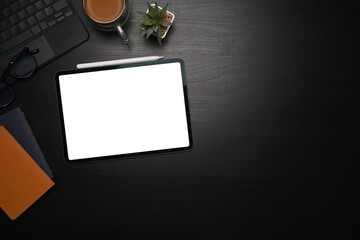 Mock up digital tablet, stylus pen, notebooks and coffee cup on black table.