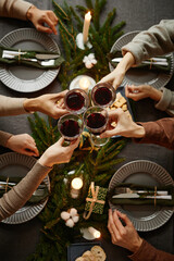 Top view background of four people enjoying Christmas dinner together and toasting with wine...