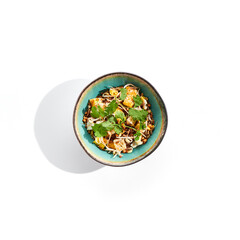 Traditional Chinese dish - fried rice with egg and vegetable. Asian wok with rice and shredded omelette on white background. Nasi goreng with egg on isolated background with shadows.