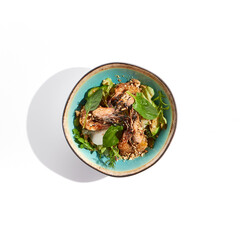 Green salad with grilled prawns and vegetables. Healthy food in restaurant menu. Shrimp with salad mix and peanuts - delicious dish for keto diet. Restaurant dish isolated on white background.