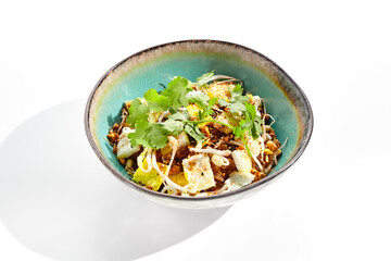 Traditional Chinese dish - fried rice with egg and vegetable. Asian wok with rice and shredded omelette on white background. Nasi goreng with egg on isolated background with shadows.