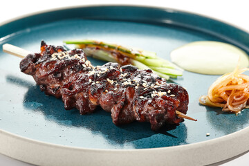 Food in Japanese restaurant - skewer yakitori with beef and teriyaki sauce. Grilled beef black Angus  on bamboo stick in Japanese style. Bbq menu for asian restaurant. Yakitori on white background.