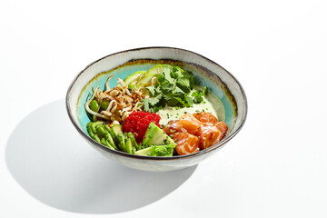 Healthy food - poke bowl with salmon, rice, cucumber, avocado, edamame beans, soybean sprouts and ponzu sauce. Hawaiian meal poke bowl with salmon isolated on white background.