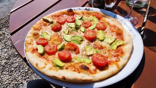 Delicious Pizza with avocado and tomato