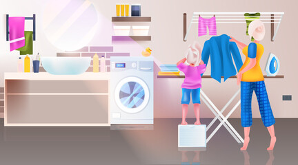 mother with daughter ironing clothes in bathroom full length horizontal