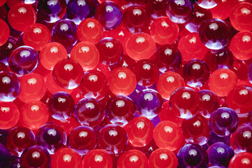 Close-up shot of multicolored water gel balloons, red and purple.